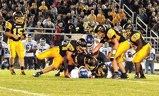 
The Fulton defense gangs up on
a Boonville rusher in the Hornets'
47-13 rout of the Pirates last Friday
night in Fulton.