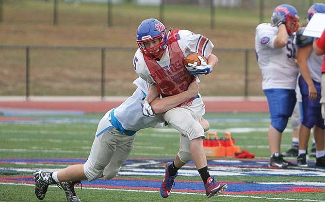 
Jacob Wolken makes a tackle on a California teammate during Tuesday's practice at the school. Wolken, the starting
quarterback, is becoming a reliable tackler on defense from the outside linebacker position.