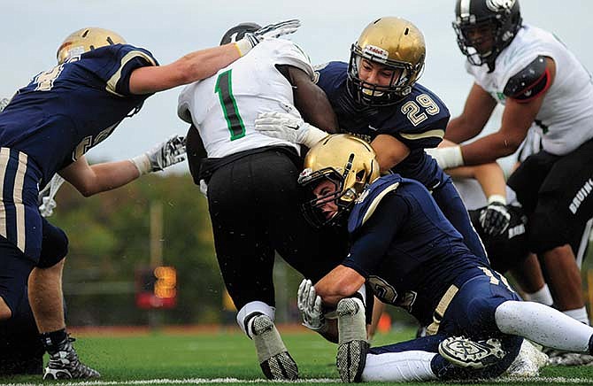 Helias
defenders
Dalton
Weaver
(2), Dylan
Gaines (29)
and Logan
Distler (54)
collide with
Rock Bridge
running
back Nick
Collins as
he comes
out of the
Bruins' end
zone and
narrowly
avoids
the safety
during last
Saturday
afternoon's
game at
Adkins Stadium.