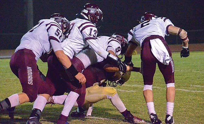 
A swarm of School of the Osage defenders gang tackle an Eldon runner
during last Friday night's game.