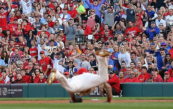 St Louis Cardinals' Kolten Wong dives for a wild throw by pitcher Jaime Garcia in the second inning of Game 2 in baseball's National League Division Series against the Chicago Cubs, Saturday, Oct. 10, 2015, in St. Louis. (J.B. Forbes/St. Louis Post-Dispatch via AP) 