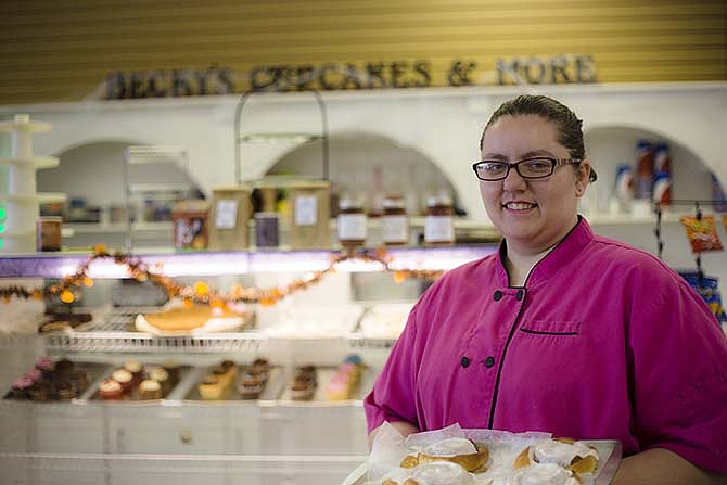 
Becky Stephenson of Becky's Cupcakes & More holds a tray of big cinnamon rolls at
her recently-opened Missouri Boulevard location in Jefferson City.