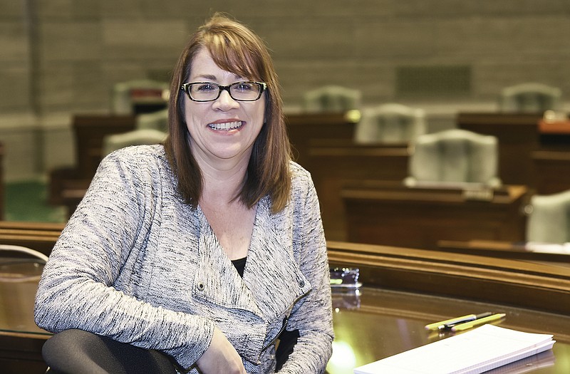 Adriane Crouse poses at her desk in the Missouri Senate chamber. 
