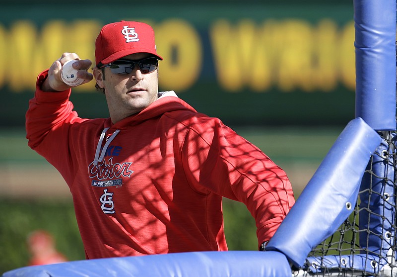 Cardinals manager Mike Matheny throws a ball during practice Sunday in Chicago.