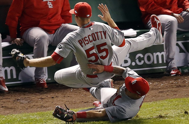Stephen Piscotty collides with Cardinals teammate Kolten Wong as he catches a foul ball hit by Starlin Castro of the Cubs during the fifth inning of Monday night's NLDS game in Chicago.