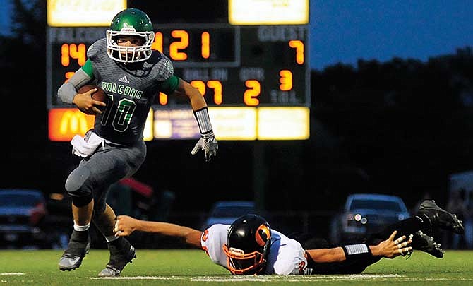 
Blair Oaks quarterback Jordan Hair accelerates to the sideline as Owensville strong safety Robert Wierich lunges for Hair's legs during a game this season in Wardsville.