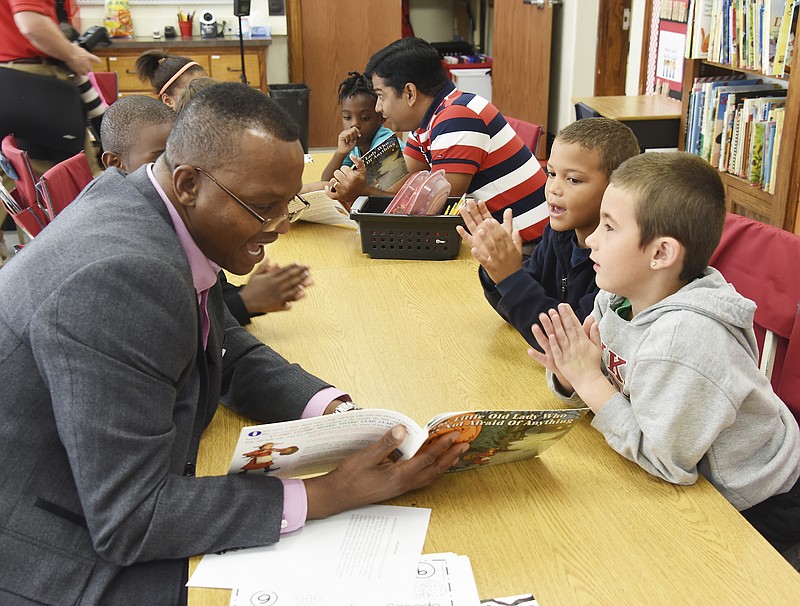 Paul Andrews, left, is animated as he reads to first-grade students in Tawnya Veit's classroom as East School welcomed guest readers and their books Friday morning. Andrews works for Wipro Infocrossing and was among several employees who volunteered their time to read the book "The Little Old Lady Who Was Not Afraid Of Anything." Students Deven Womack, right, and Earnest Holt, clap their hands when it's called for in the book.