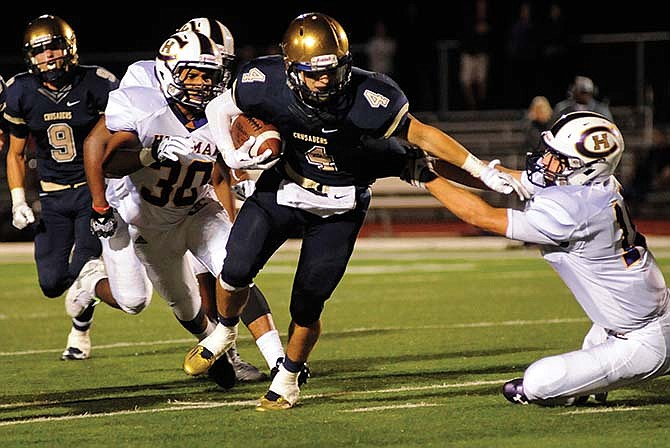 
Nolan
Sachse of
Helias picks
up extra
yardage as
he pushes
away a
Hickman
defender
during a
game earlier
this
season at
Adkins Stadium.