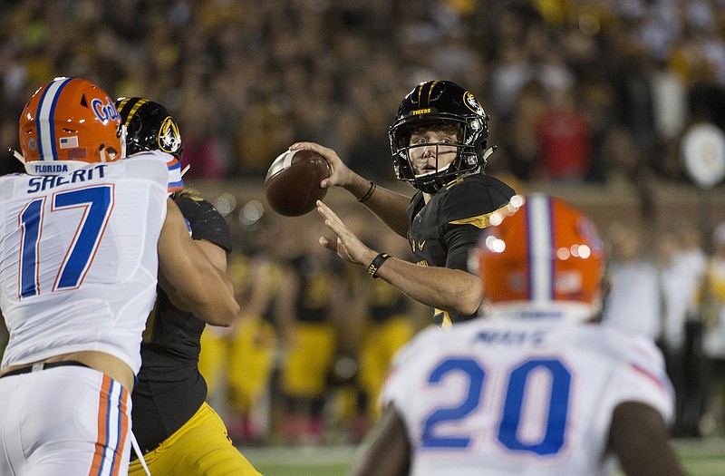 Missouri quarterback Drew Lock, center, throws a pass between Florida's Jordan Sherit, left, and Marcus Maye, right, during the first half of an NCAA college football game, Saturday, Oct. 10 2015, in Columbia, Mo. 