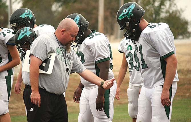 
North
Callaway
head coach
Kevin O'Neal
goes
over blocking
assignments
with
some of his
offensive
linemen
during
a recent
practice at
the high
school in
Kingdom
City.