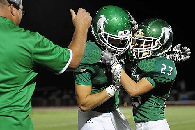 Blair Oaks wide receiver Ethan Luebbering (23) celebrates on the
sideline with teammate Jake Van Ronzelen (7) after hauling in a touchdown
reception during Friday night's game against Versailles in Wardsville.