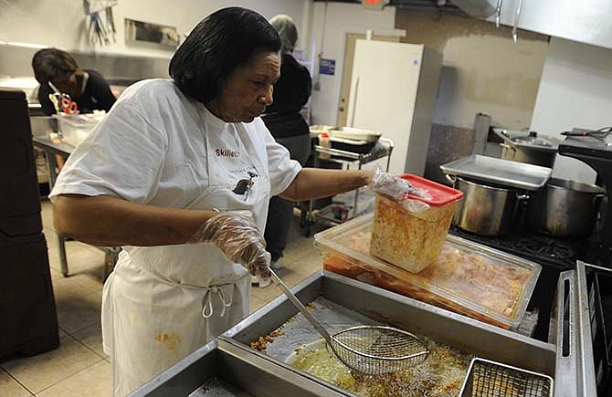 
Barbara Porter, mother of The Blue Skillet owner Phillippia Rome tends to a fresh batch
of southern fried chicken while working in the kitchen of the new soul food restaurant
at the corner of Dunklin and Monroe streets.