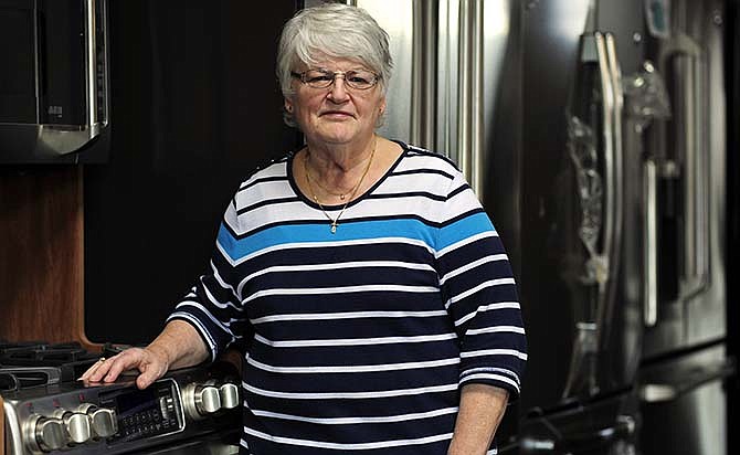 Marilyn Herigon stands beside the types of home and kitchen staples she has sold at Coleman Appliance for decades. Herigon has been a salesperson and at one time part-owner of the Jefferson City business.