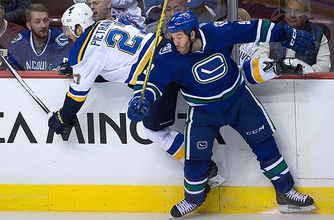 St. Louis Blues' Alex Pietrangelo, left, and Vancouver Canucks' Brandon Prust collide during the second period of an NHL hockey game, Friday, Oct. 16, 2015, in Vancouver, British Columbia (Darryl Dyck/The Canadian Press via AP) 