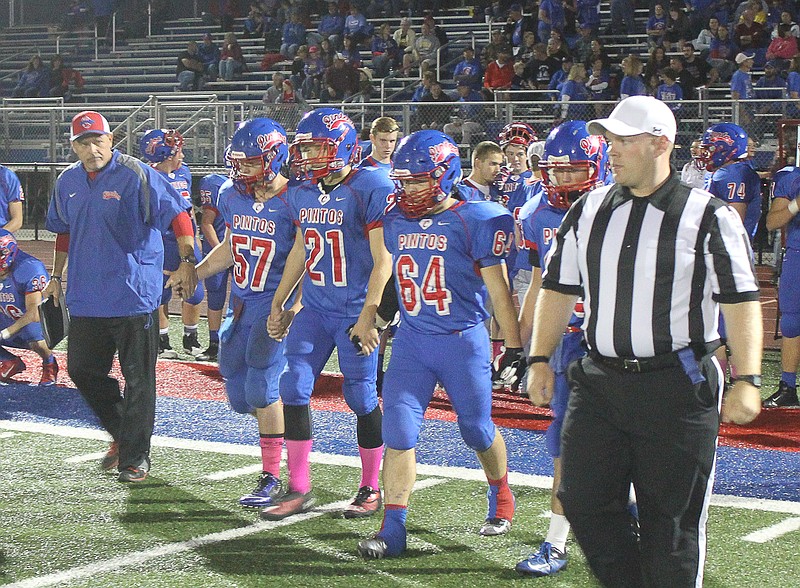 The Pintos' captains make their walk to midfield of the coin toss Friday night.