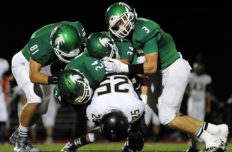 Blair Oaks defenders Owen Luebbering (81), Drew Boessen (24), Brenden Brown (34) and Cody Alexander (3) swarm Versailles running back Grant Hutchison for a stop during last Friday night's game in Wardsville.