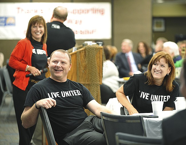 Ann Bax, standing in background, Matt Tollerton, foreground left, and Barb Prasad, seated at right, all laugh at the video playing before them during Thursday's United Way of Central Missouri victory celebration breakfast at Missouri Farm Bureau. They were able to announce that this year's campaign totals are projected to surpass the original goal by $9,000.