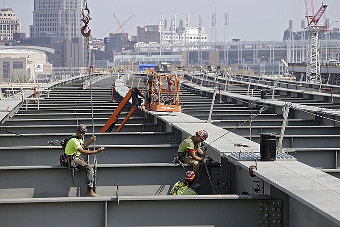 Ironworkers secure a cross member on a highway bridge under construction in Cleveland in 2013. The House has voted to continue transportation programs for six years with no significant increase in spending. 