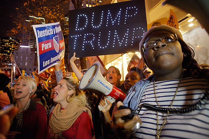 Sasha Murphy, of the ANSWER Coalition, leads demonstrators in a chant during a protest against Republican presidential candidate Donald Trump's hosting "Saturday Night Live" in New York, Saturday, Nov. 7, 2015. Despite a 40-year history of lampooning politicians while inviting some to mock themselves as on-air guests, booking a presidential candidate to host the NBC sketch-comedy show is almost unprecedented. 