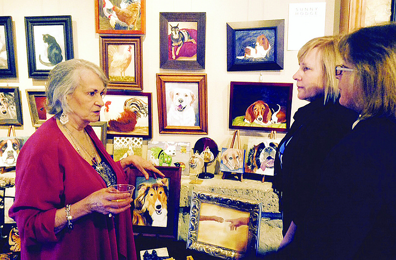 Sunny Hodge, left, the featured artist at Capital Arts annual "Give the Gift of Art" event on Sunday, chats, from left, with Laura Elsbury and Linda Stone.