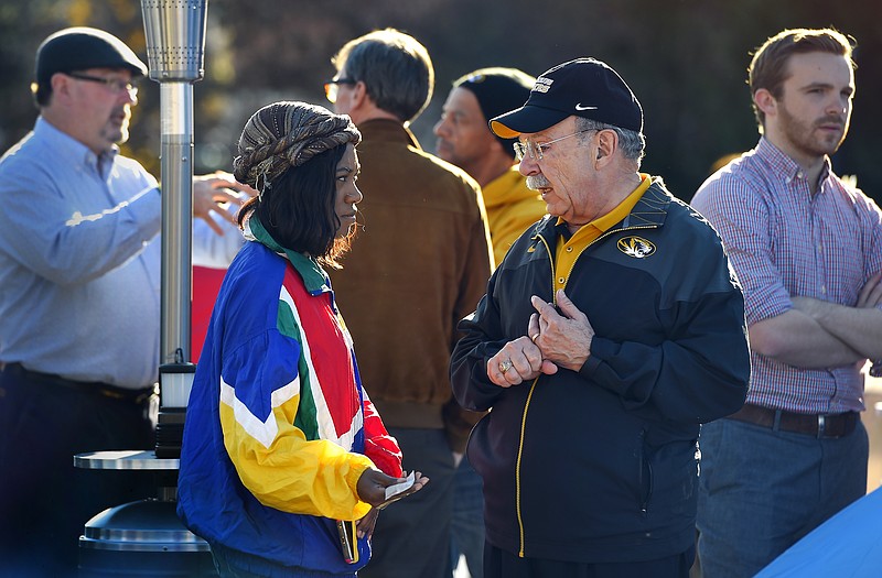 University of Missouri chancellor R. Bowen Loftin (right) speaks with an unidentified person Sunday at the location where student protesters have put up tents on the campus in Columbia.