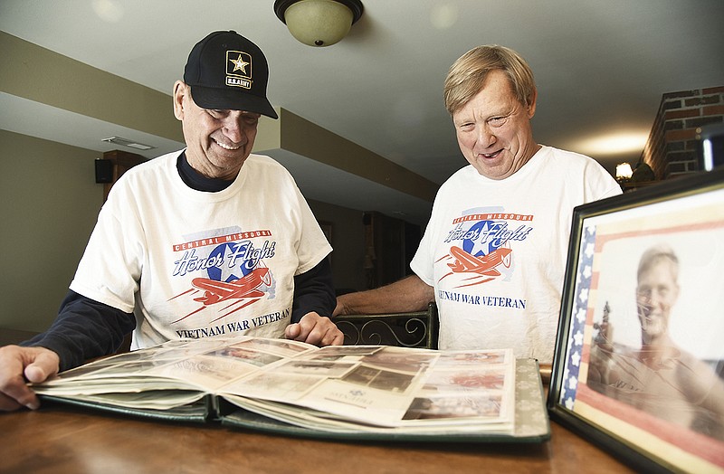 Jefferson City natives Don, left, and John Prenger smile as they talk about their Nov. 3 Honor Flight trip to Washington, D.C. Both men served with the U.S. Army in Vietnam, Don from 1966-68 and John from 1969-70. In the foreground at right is a photograph of John. 
