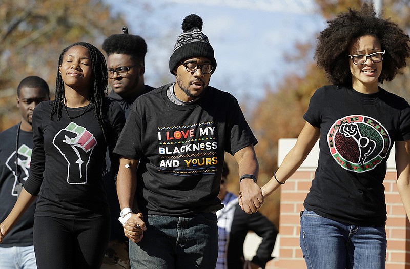 Jonathan Butler, center, is helped onto a stage before addressing a crowd following the announcement that University of Missouri System President Tim Wolfe would resign Monday at the university in Columbia. Butler has ended his hunger strike as a result of the resignation. 