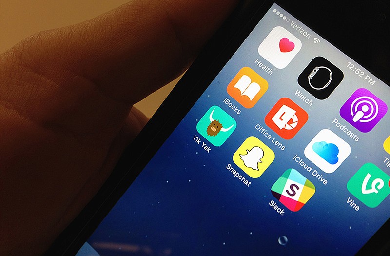 The Yik Yak app, lower, left, is seen on an iPhone in Washington. Internet users of the Yik Yak social media gossip app popular among college students aren't nearly as anonymous as they believe: Missouri police within hours arrested a student accused of threatening violence, the latest in a string of such arrests at colleges in recent months involving threats posted online. 