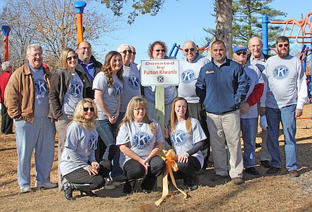 Members of the Fulton Kiwanis prepare to cut the ribbon on a new swing that accommodates children with disabilities. The Kiwanis received a $3,700 grant to help cover the costs of the $9,000 swing.