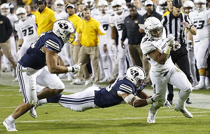 Missouri running back Russell Hansbrough, right, slips past BYU linebackers Jherremya Leuta-Douyere, center, and Harvey Langi, left, in the first half of a college football game at Arrowhead Stadium, Saturday, Nov. 14, 2015, in Kansas City, Mo.