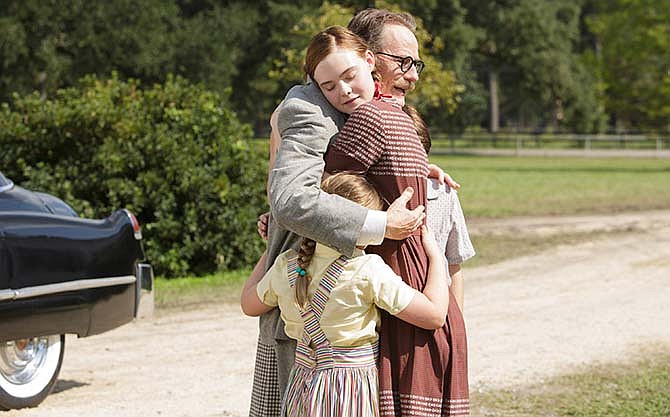 This photo provided by Bleecker Street shows Bryan Cranston, right, as Dalton Trumbo, embracing his children, with Elle Fanning, left, as Niki Trumbo, in Jay Roach's "Trumbo," a Bleecker Street release. 