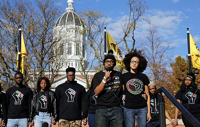 In this Nov. 9, 2015, file photo, Jonathan Butler, center, addresses a crowd following the announcement that University of Missouri System President Tim Wolfe would resign, in Columbia, Mo. The bullet points are blunt and direct: Blacks at the University of Missouri are harassed and threatened, the university has too few African-American faculty members, administration doesn't seem to care, and all of that needs to change. A set of demands addressing those concerns is strikingly similar to demands made in 1969. But this time, it appears the university is listening.