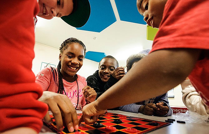 Koi Harry, left, looks to make her next move while playing a
"house rules" game of checkers with a group of friends during
an afternoon of activities as part of the South Elementary
School's Boys & Girls Club after school program on Friday.