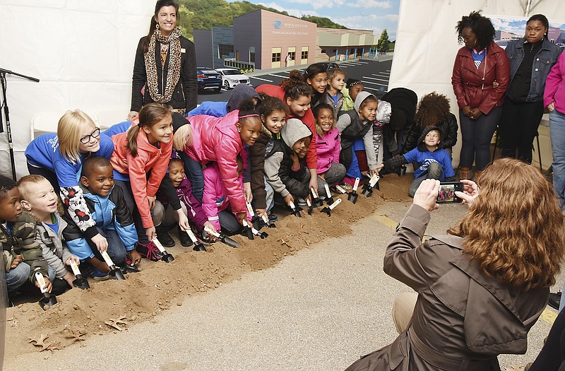 Standing in front of Mayor Carrie Tergin and an oversized poster of the new Boys and Girls Club of the Capital City, several club youngsters dig into the dirt to celebrate the next step in getting their new building completed.
