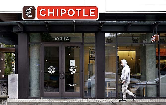 A pedestrian walks past a closed Chipotle restaurant Monday, Nov. 2, 2015, in Seattle. An E. coli outbreak linked to Chipotle restaurants in Washington state and Oregon has sickened nearly two dozen people in the third outbreak of foodborne illness at the popular chain this year. Cases of the bacterial illness were traced to six of the fast-casual Mexican food restaurants, but the company voluntarily closed down 43 of its locations in the two states as a precaution. They have since reopened.