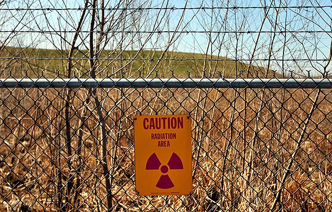 In this March 13, 2012 photo, a radiation warning sign hangs on a fence at the West Lake landfill in Bridgeton, Mo.