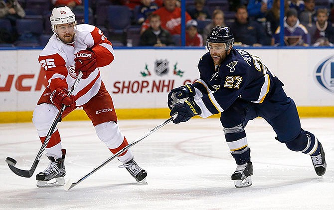 Detroit Red Wings' Mike Green, left, lifts the puck past St. Louis Blues' Alex Pietrangelo during the second period of an NHL hockey game Saturday, Nov. 21, 2015, in St. Louis.