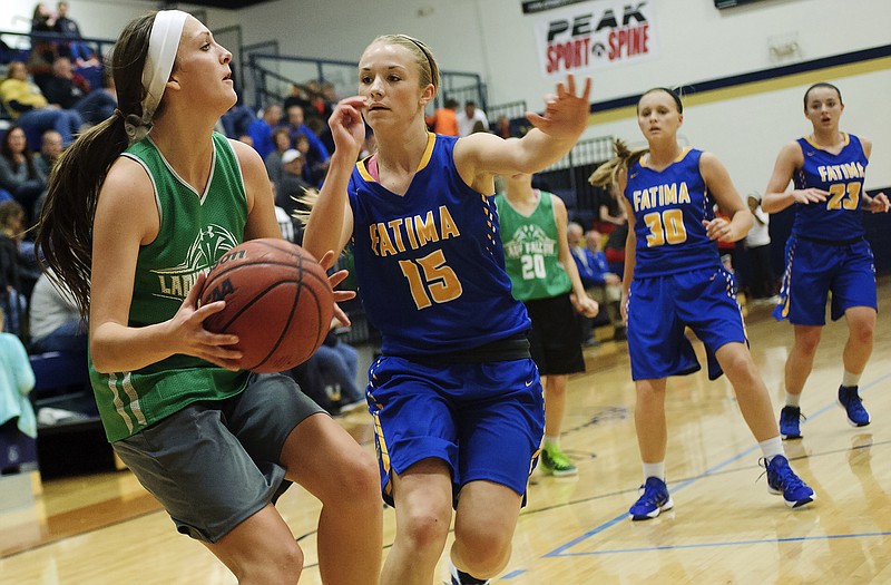 Blair Oaks Macyn Wilbers looks to dish to an open teammate as Fatima's Morgan Berhorst closes in during Friday night's Jamboree at Helias.