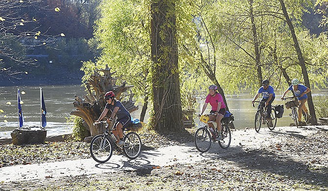 A group of bicyclists ride earlier this month on the newly-poured concrete path known as the river walk, which stretches from the Noren Access to the access parking lot in north Jefferson City.