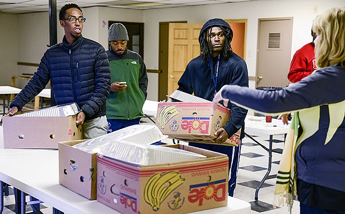 Lincoln University students Dennis Jackson, left, Amani Nelson, center, and Kristopher
Hudson stock up on Thanksgiving dinner packages Saturday while receiving delivery
directions from Eileen Scrivner, turkey dinner project coordinator at the Elks Lodge in Jefferson City.
