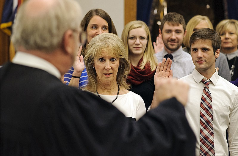 
Sharon Lowder, second from left, raises her right hand alongside Alex LeCure, right, and nine other volunteers as Cole County Circuit Court Judge Jon Beetem, left, presides over the ceremony for newly appointed members of Capital City CASA.