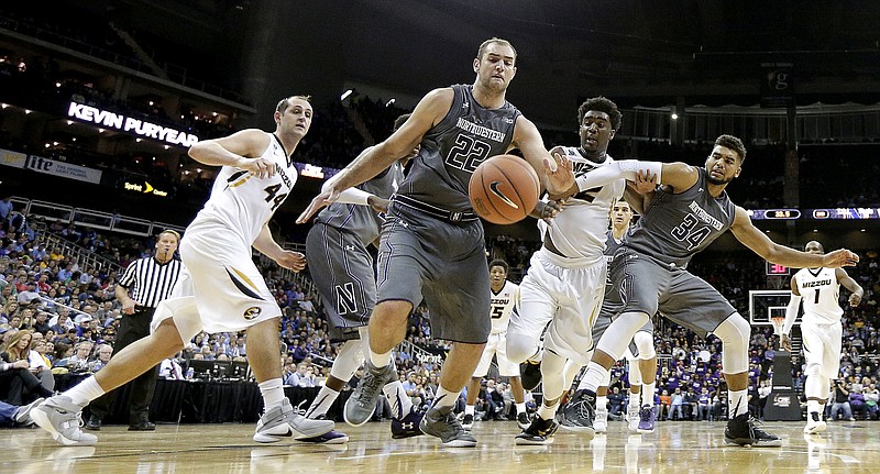 Northwestern's Alex Olah (22) and Sanjay Lumpkin (34) surround Missouri's Namon Wright as they chase a loose ball during the second half of Tuesday night's game in Kansas City.
