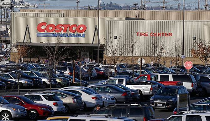 Cars fill the parking lot of a Costco store, Tuesday, Nov. 24, 2015, in Seattle. Health authorities say chicken salad from Costco has been linked to at least one case of E. coli in Washington state. 