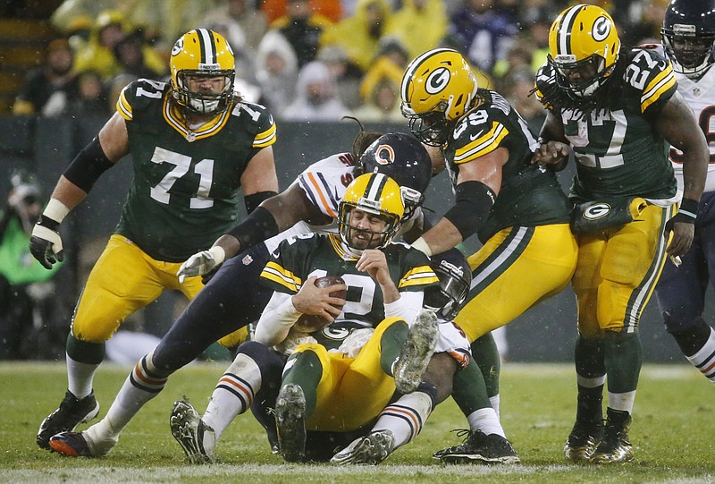 Green Bay Packers' Aaron Rodgers grimaces as he is tackled after recovering a fumble during the second half of an NFL football game against the Chicago Bears Thursday, Nov. 26, 2015, in Green Bay, Wis. 