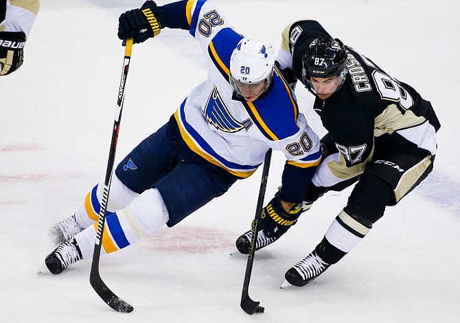 Pittsburgh Penguins' Sidney Crosby (87) and St. Louis Blues' Alexander Steen (20) battle for the puck during the first period of an NHL hockey game in Pittsburgh Wednesday, Nov. 25, 2015.