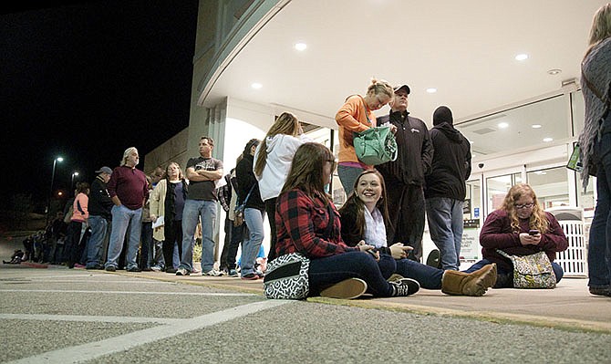 Reece Chiles, of Jefferson City, smiles at her cousin Katlyn Chiles outside of Kohl's Thursday evening as they wait in line with hundreds of others to get a head start on the Black Friday deals.