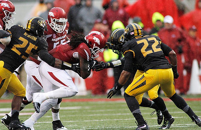 Arkansas' Alex Collins (3) attempts to break Missouri defense's tackles during the first half of an NCAA college football game Friday, Nov. 27, 2015, in Fayetteville, Ark. 