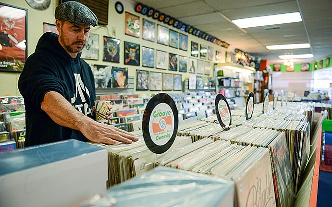Jamie Rector, owner of In The Groove Vinyl Records Shop, organizes his records upon
opening his store Saturday. Rector's record shop supplies a variety of vintage records,
tapes, CDs and furniture and was among area businesses that participated in Small Business
Saturday, which encouraged customers to shop locally.