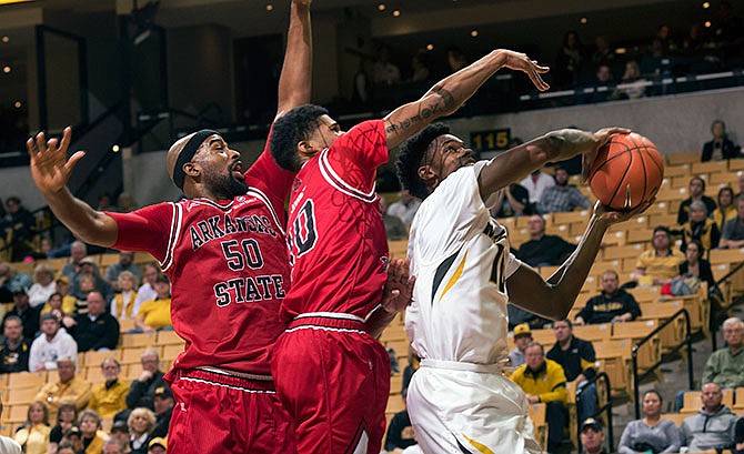 Missouri's K.J. Walton, right, pulls down a rebound past Arkansas State's Frederic Dure, center, and Anthony Livingston (50) during the first half of an NCAA college basketball game Tuesday, Dec. 1, 2015, in Columbia, Mo. 