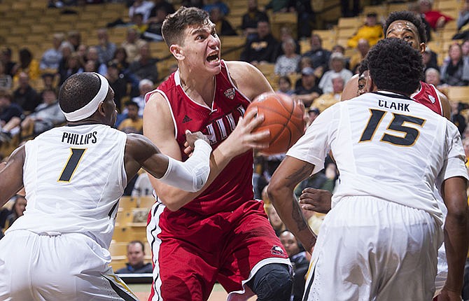 Northern Illinois's Marin Maric, center, fights his way past Missouri's Terrence Phillips, left, and Wes Clark, right, as he drives toward the basket during the second half of an NCAA college basketball game Friday, Dec. 4, 2015, in Columbia, Mo. Missouri won the game 78-71. 